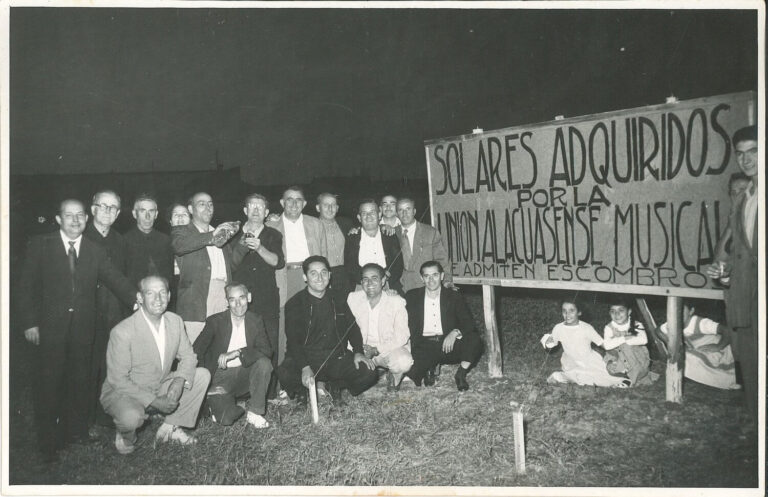 Grup de directius i socis amb el cartell de la compra del solar del Musical / 1957 Solar on es construiria el musical / Foto cedida per la família Català Bosch